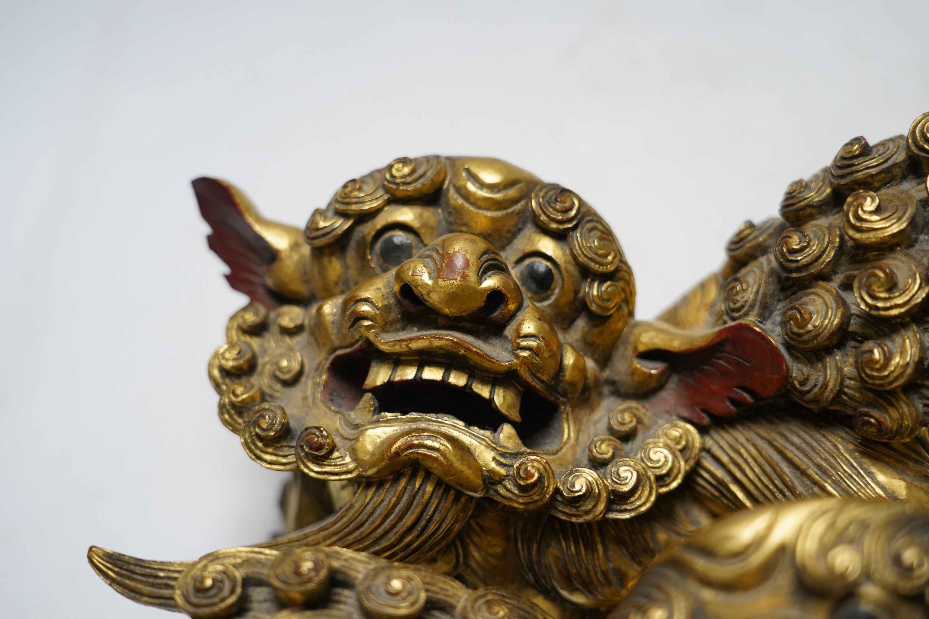 A pair of 20th century Chinese carved giltwood lion mounts, 23cm wide
